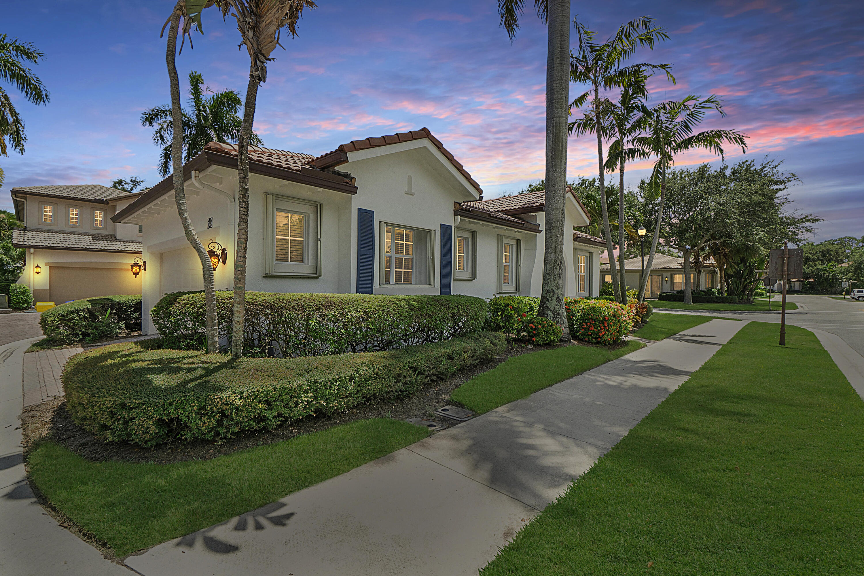 a front view of a house with a yard and potted plants