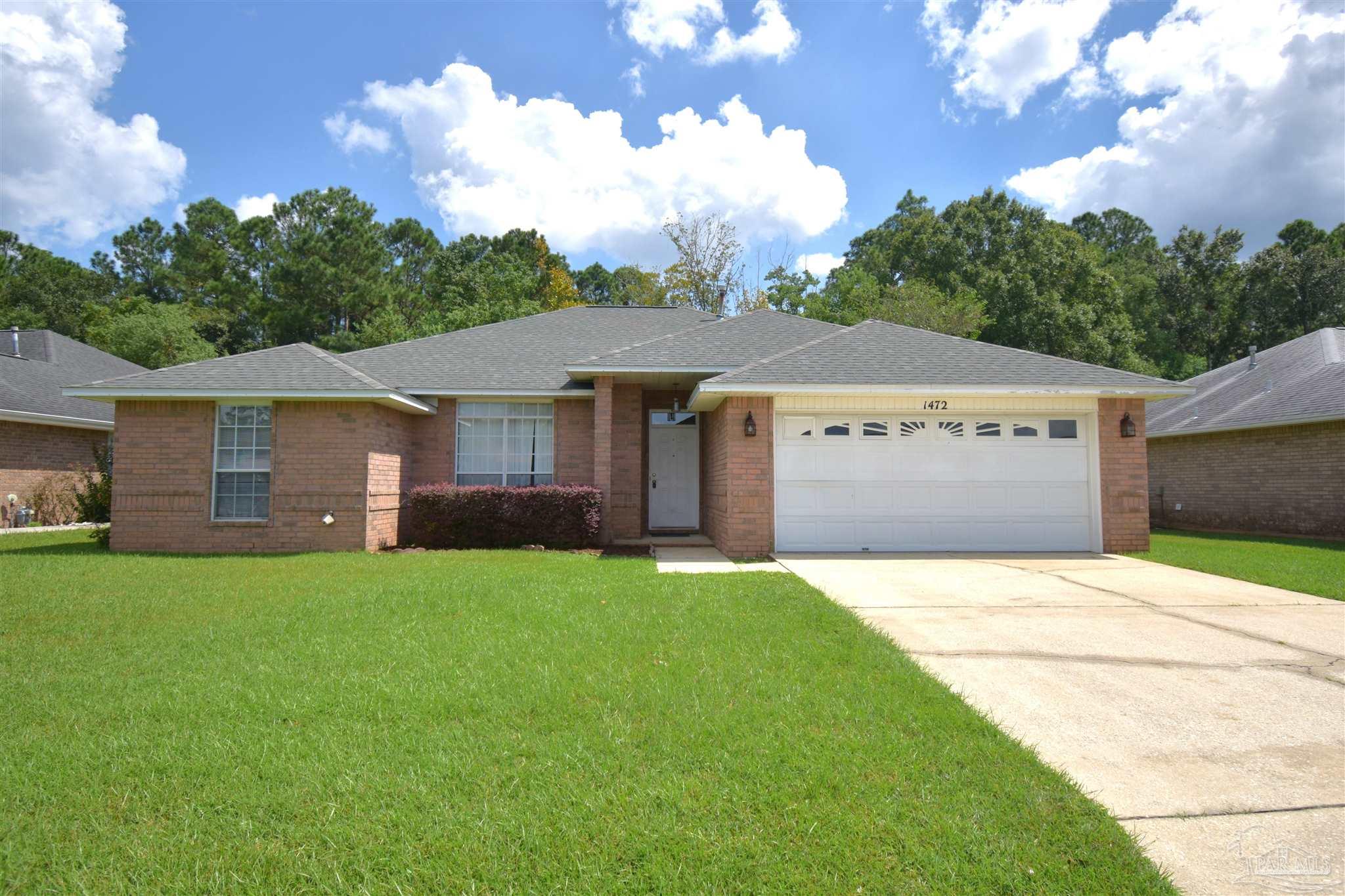 a front view of a house with a garden and yard