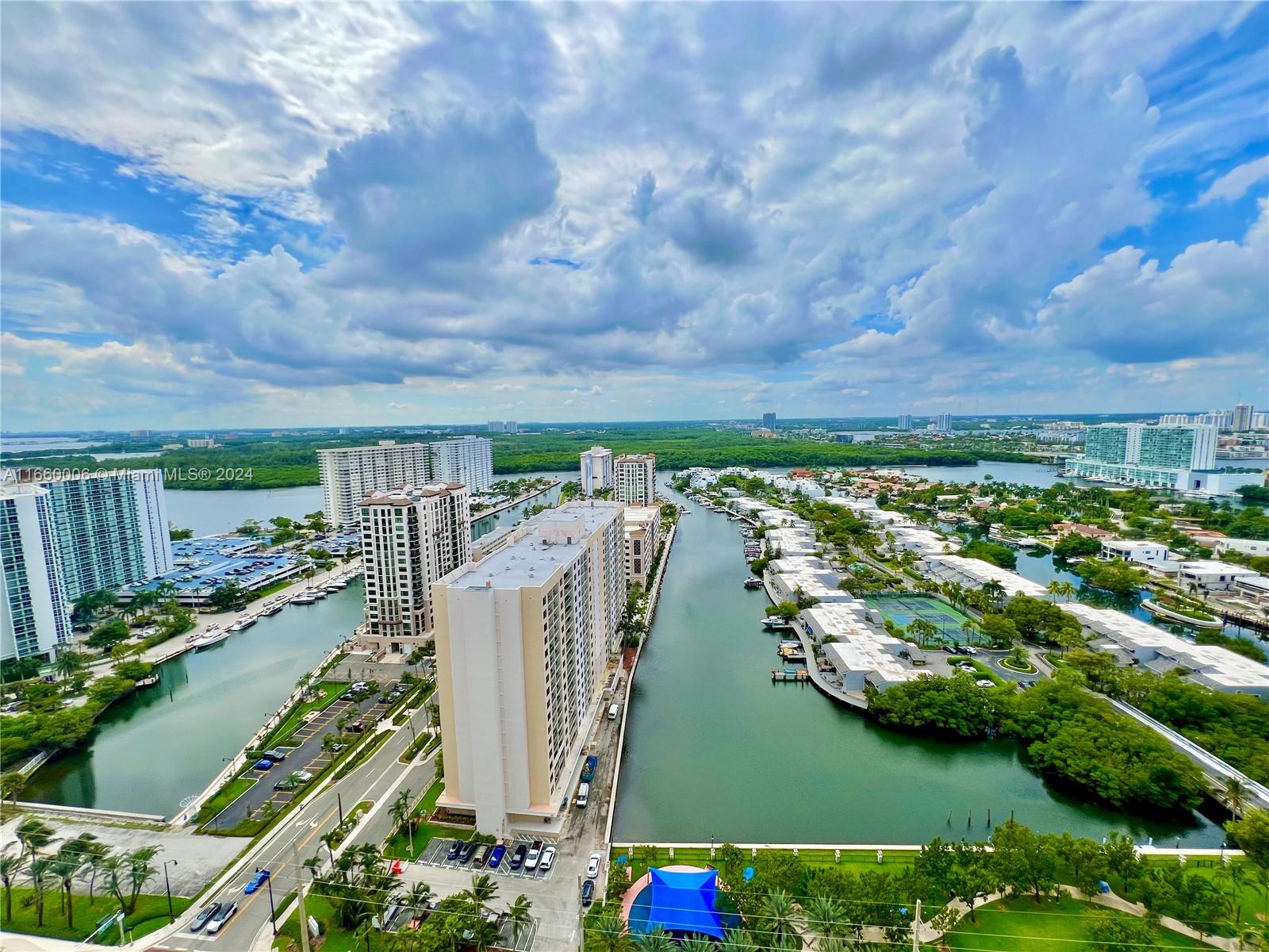 an aerial view of a house with lots of residential buildings ocean and mountain view in back