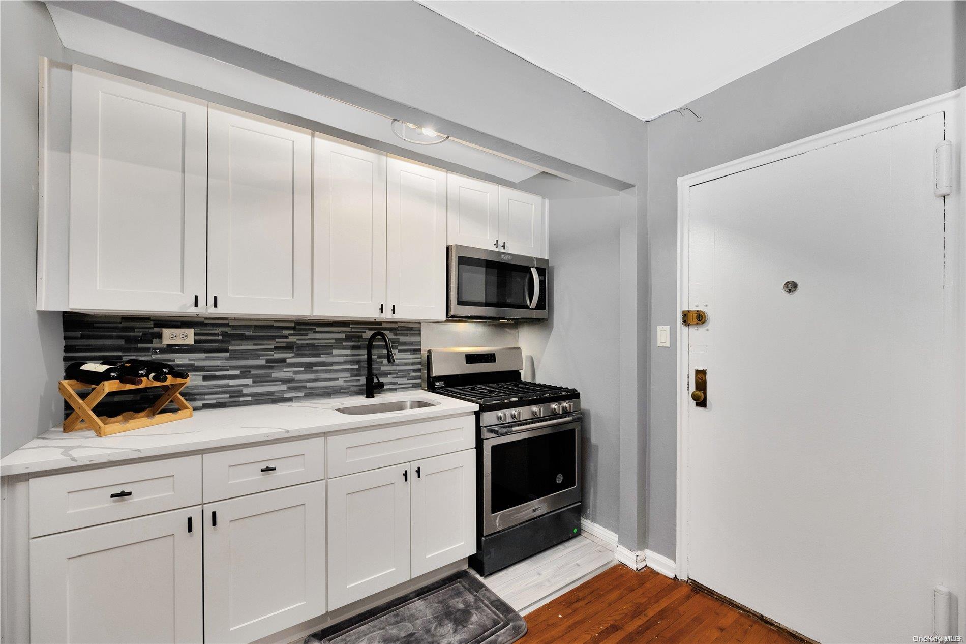 a kitchen with white cabinets and appliances