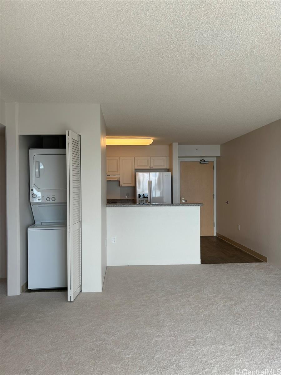 a view of a hallway to room and kitchen