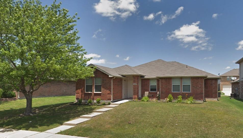 a front view of a house with a garden and trees