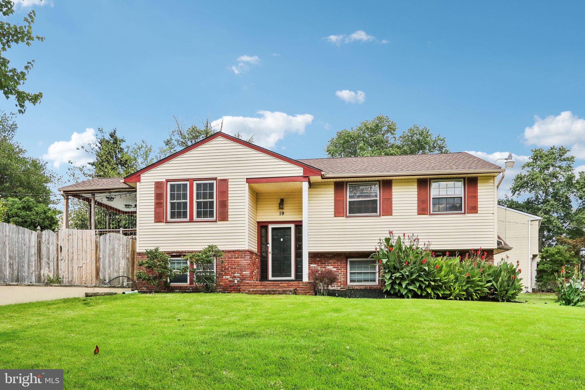 a front view of a house with a garden and yard