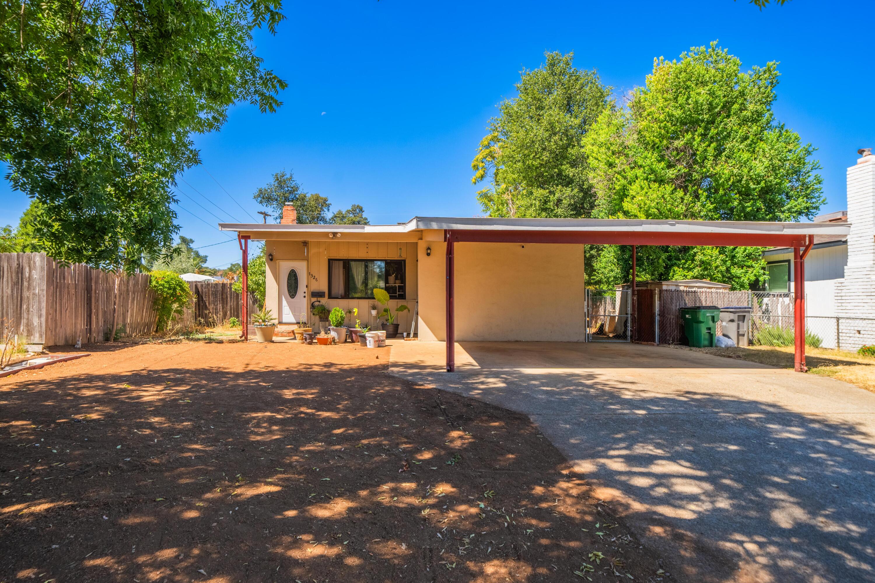 a view of a house with backyard and a tree