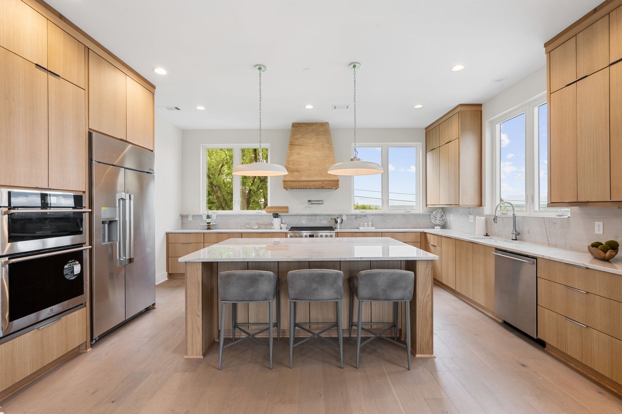 a kitchen with kitchen island granite countertop a sink a center island stainless steel appliances and cabinets