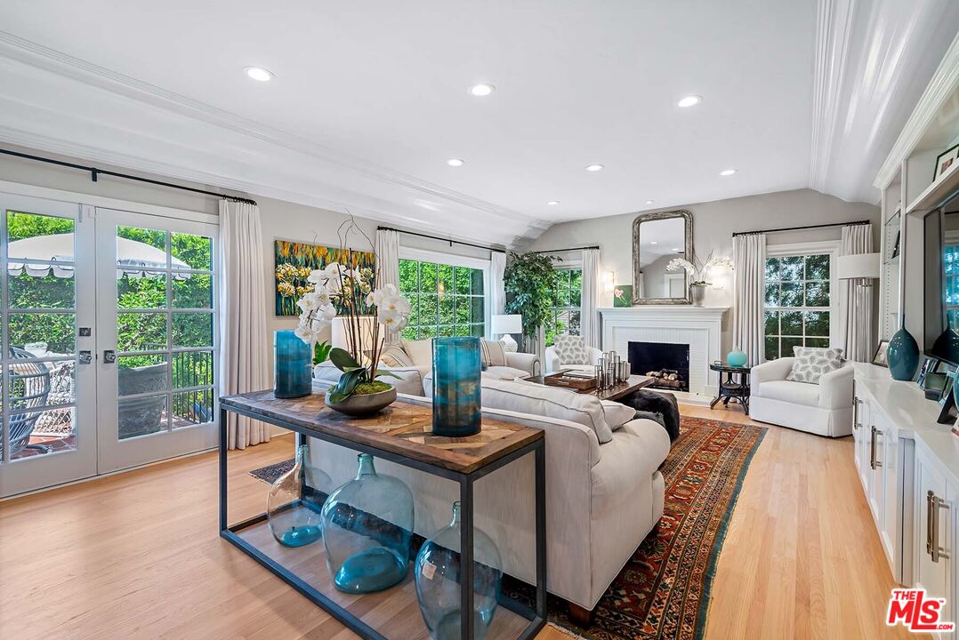 a living room with fireplace furniture and a large window