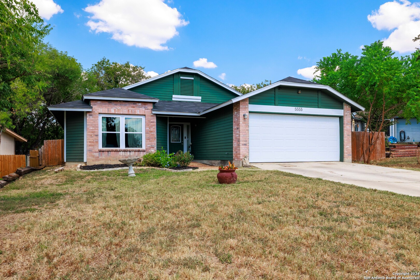 a front view of a house with yard and green space