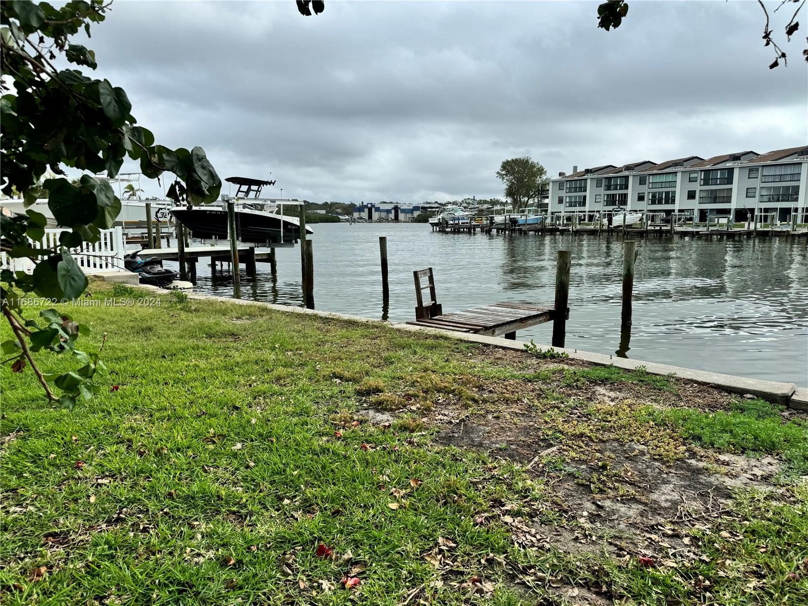 a large body of water next to a building with large trees