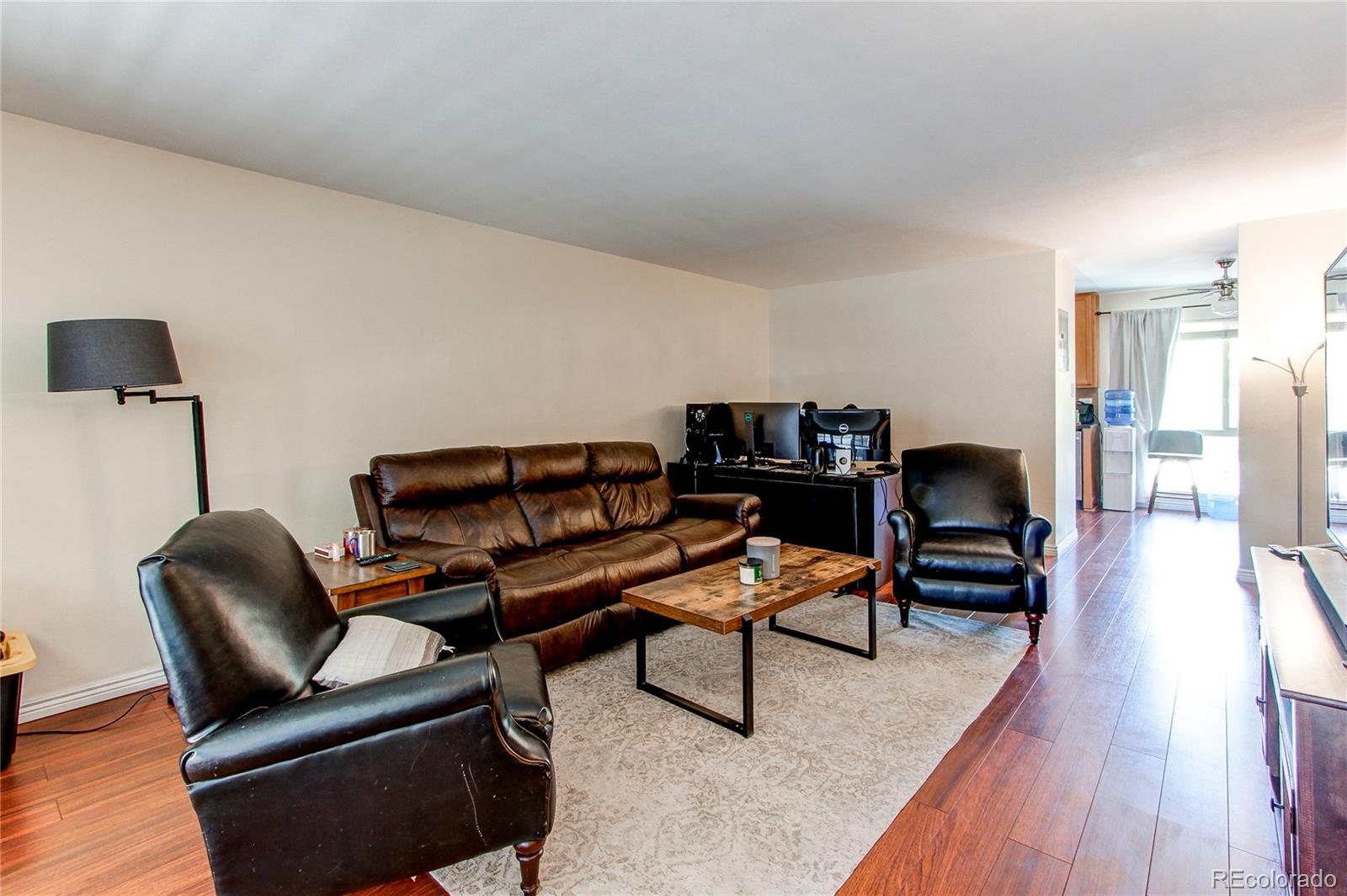 a living room with furniture and a wooden floor