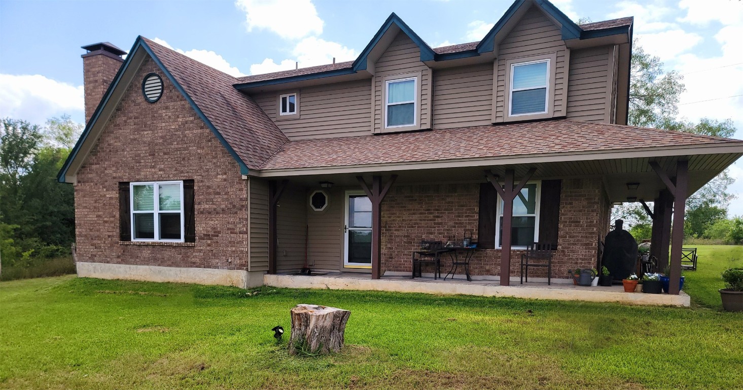 a view of a house with a yard porch and furniture