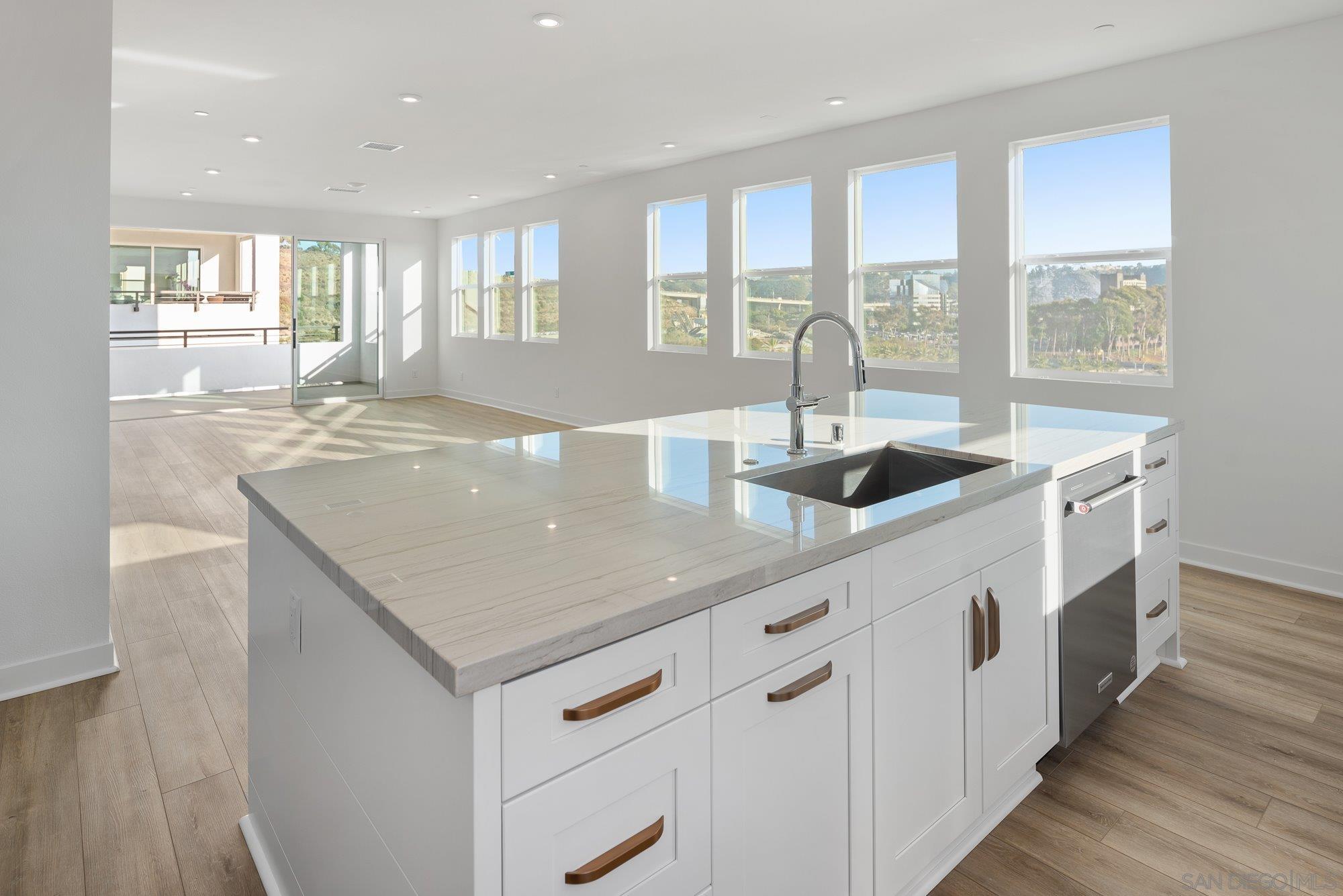 a kitchen with stainless steel appliances granite countertop a sink and a wooden floors