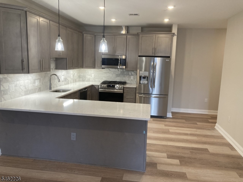 a kitchen with granite countertop a refrigerator and a sink