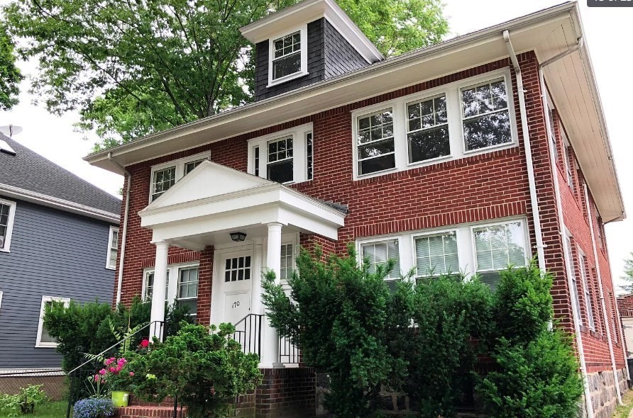 a front view of a house with plants