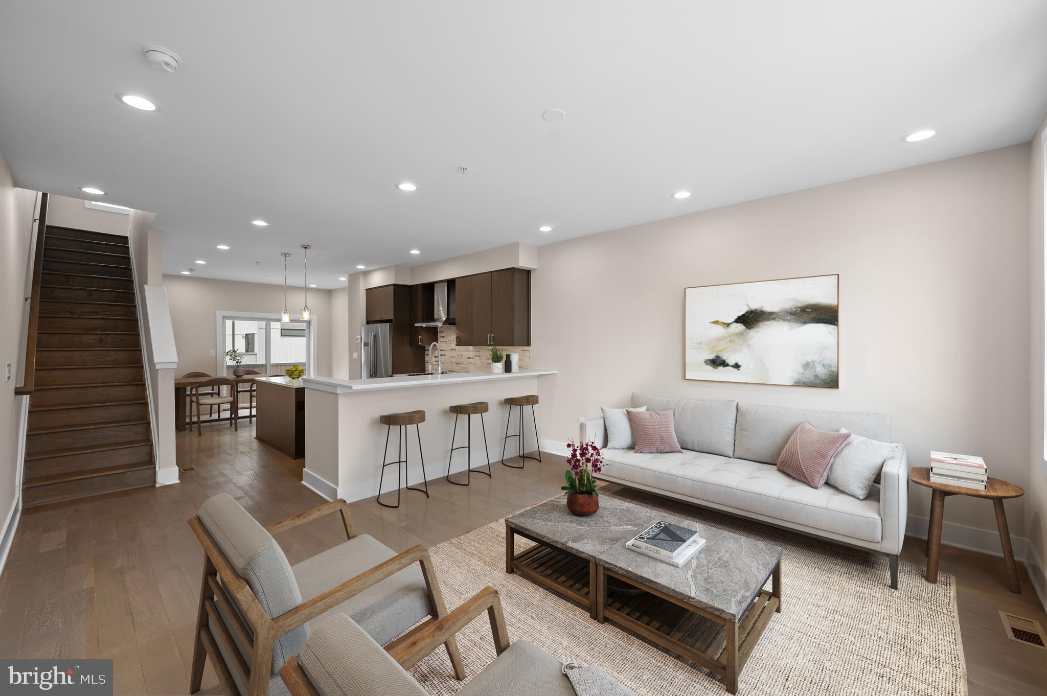 a living room with furniture and view of kitchen