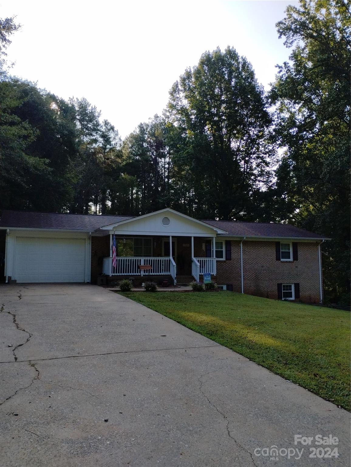 a view of a house with a yard and large trees