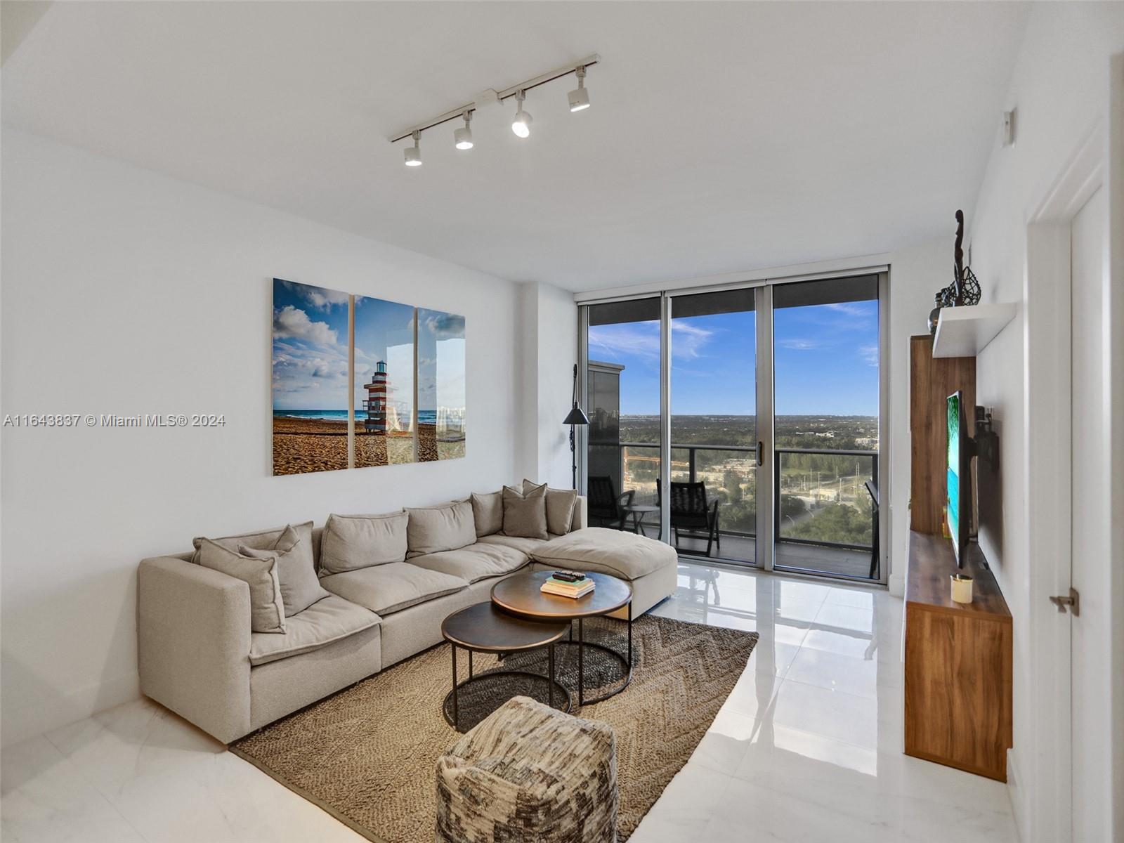 a living room with furniture and a floor to ceiling window