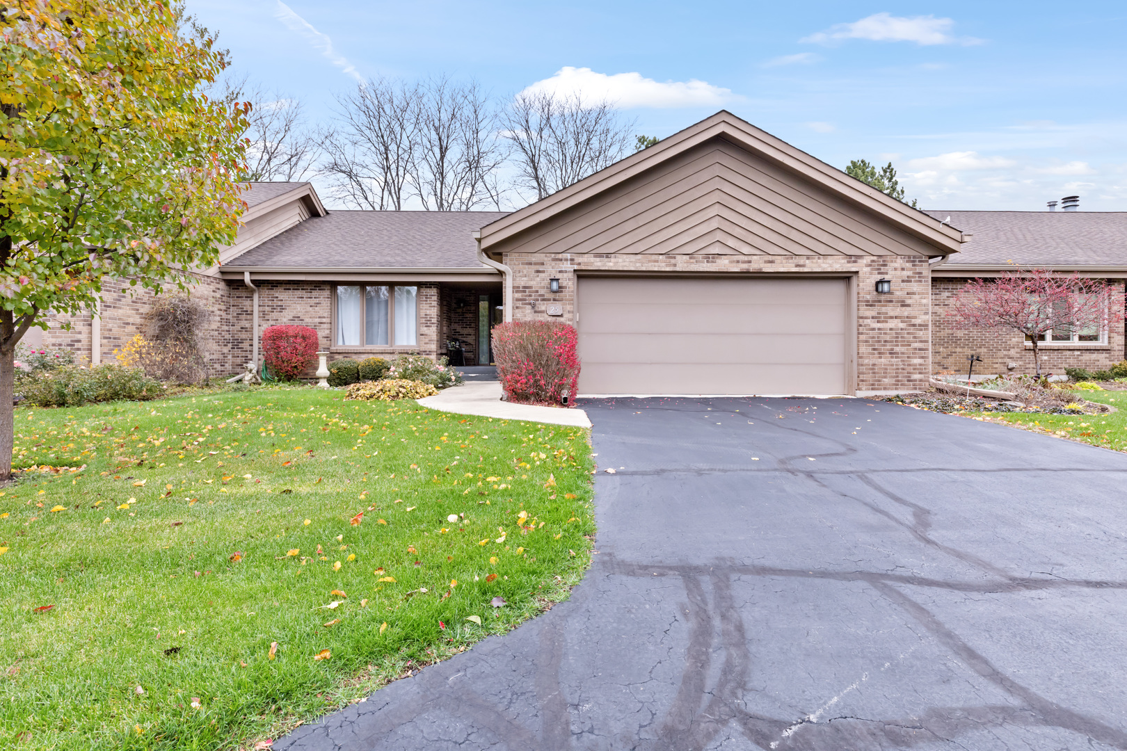 a front view of a house with yard and garage