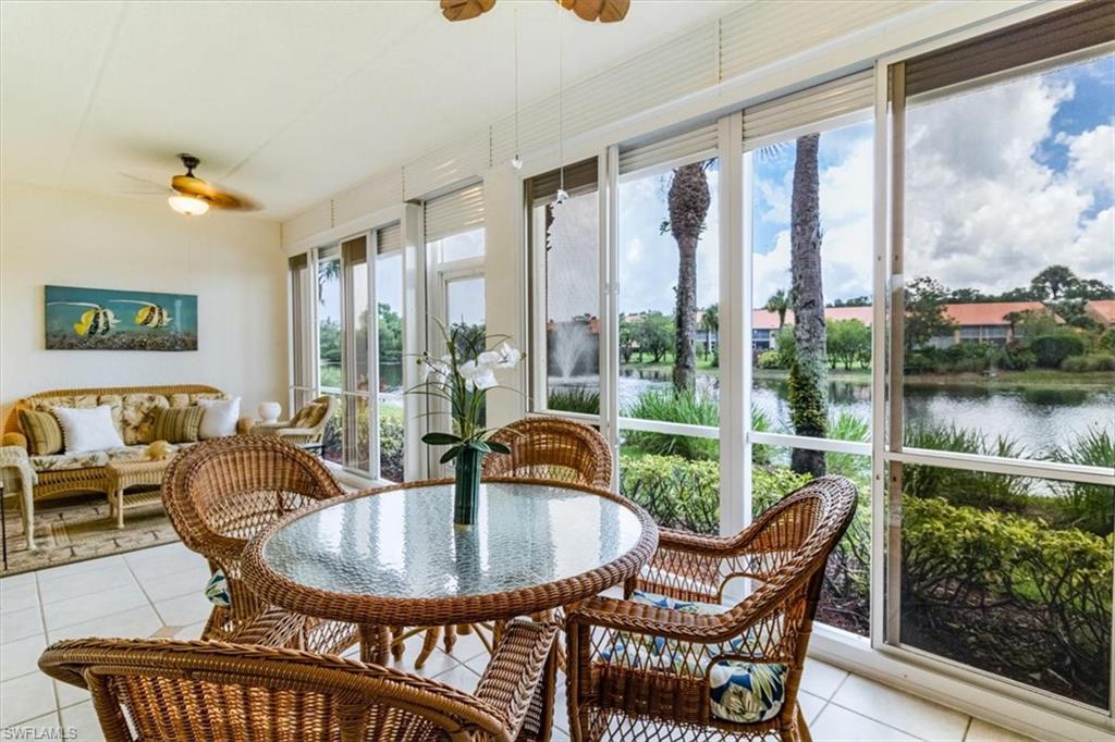 a dining room with furniture large windows and wooden floor