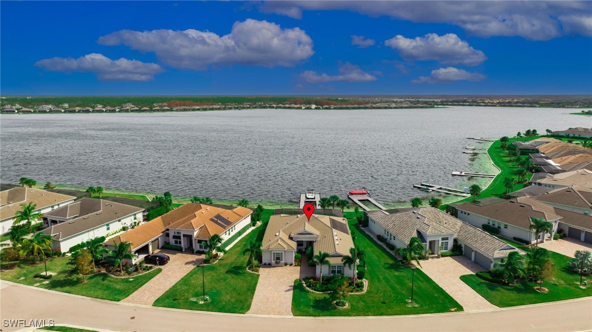 an aerial view of a house with a yard and lake view