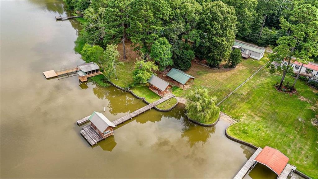 an aerial view of a house with a yard and lake view