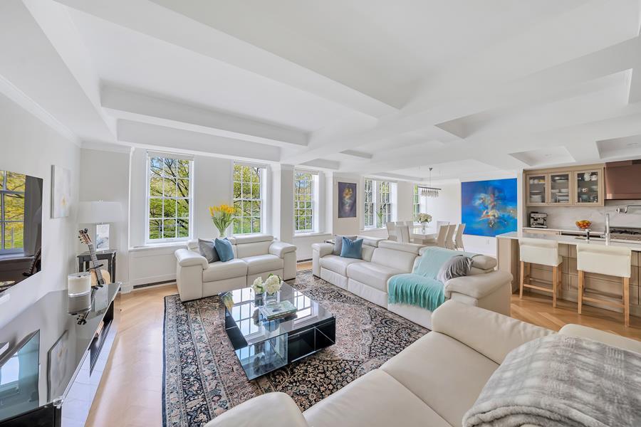 a living room with furniture wooden floor and a large window