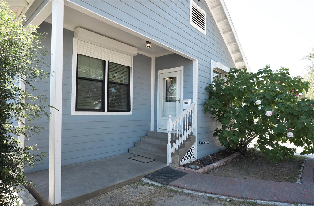 a front view of a house with a tree