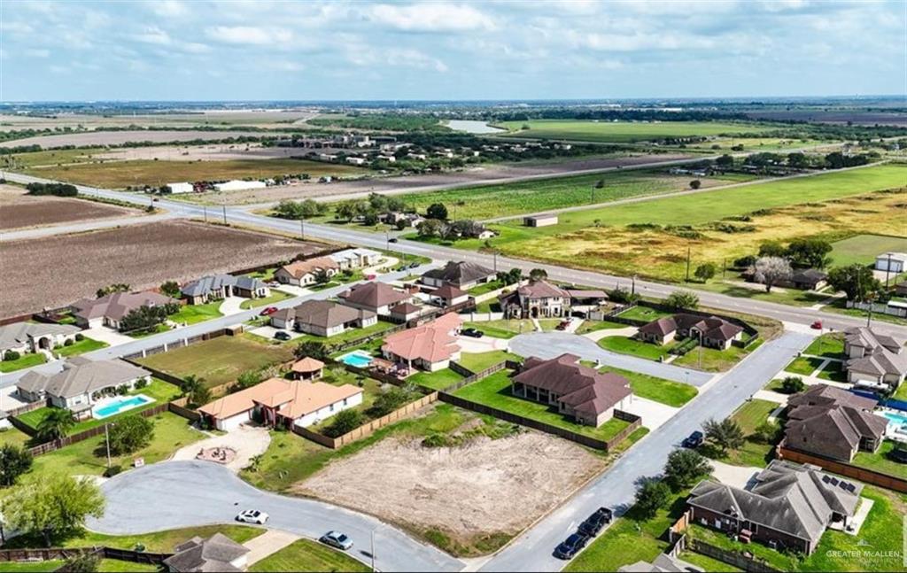 an aerial view of ocean and residential houses with outdoor space