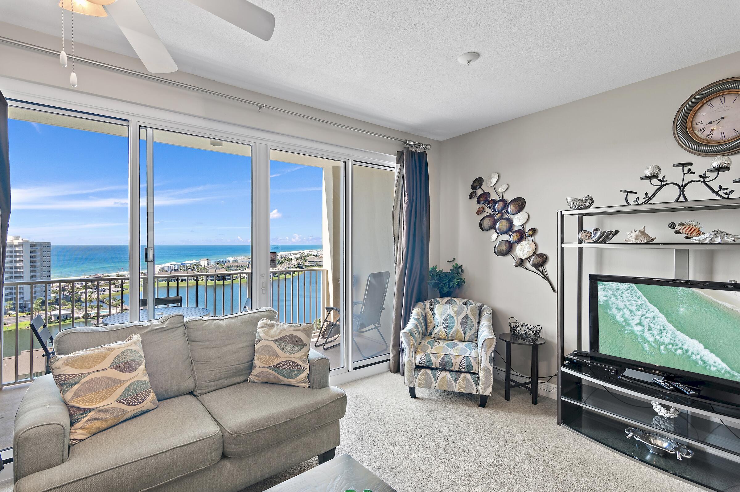 a living room with furniture tv and a floor to ceiling window