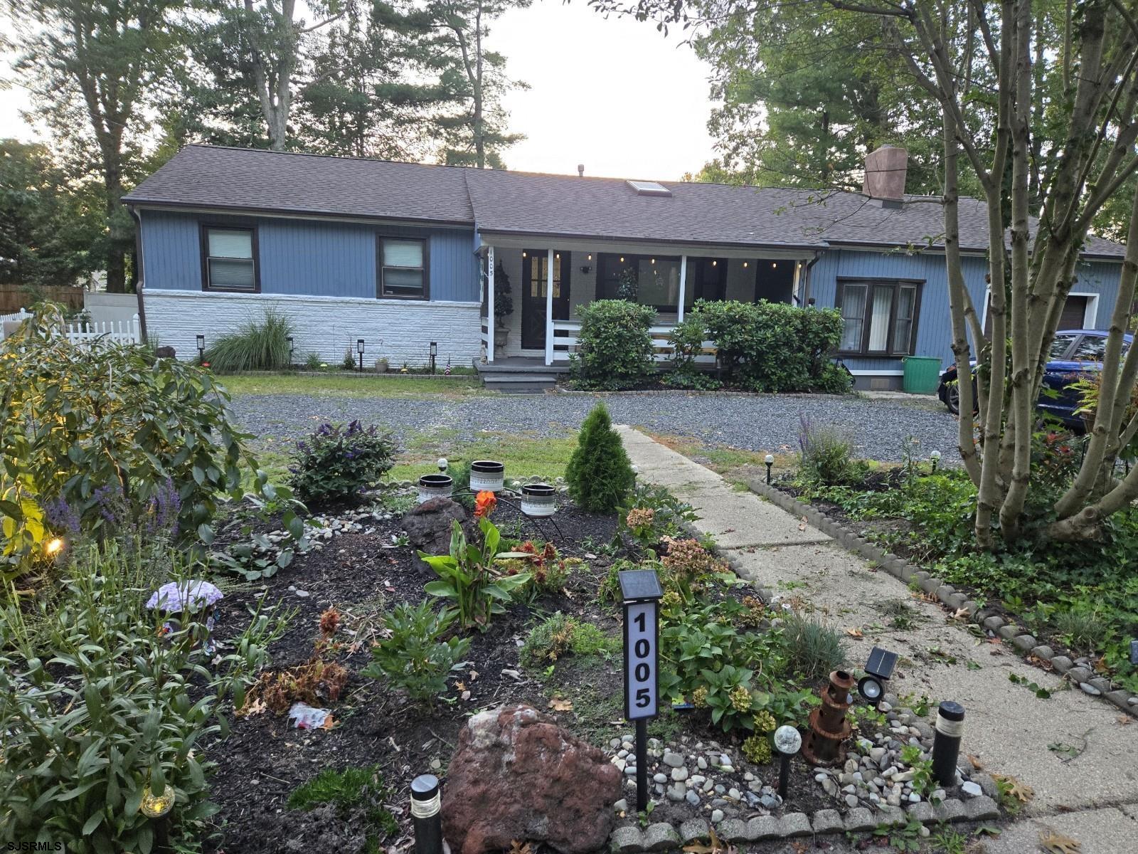 a front view of a house with a yard and a garden