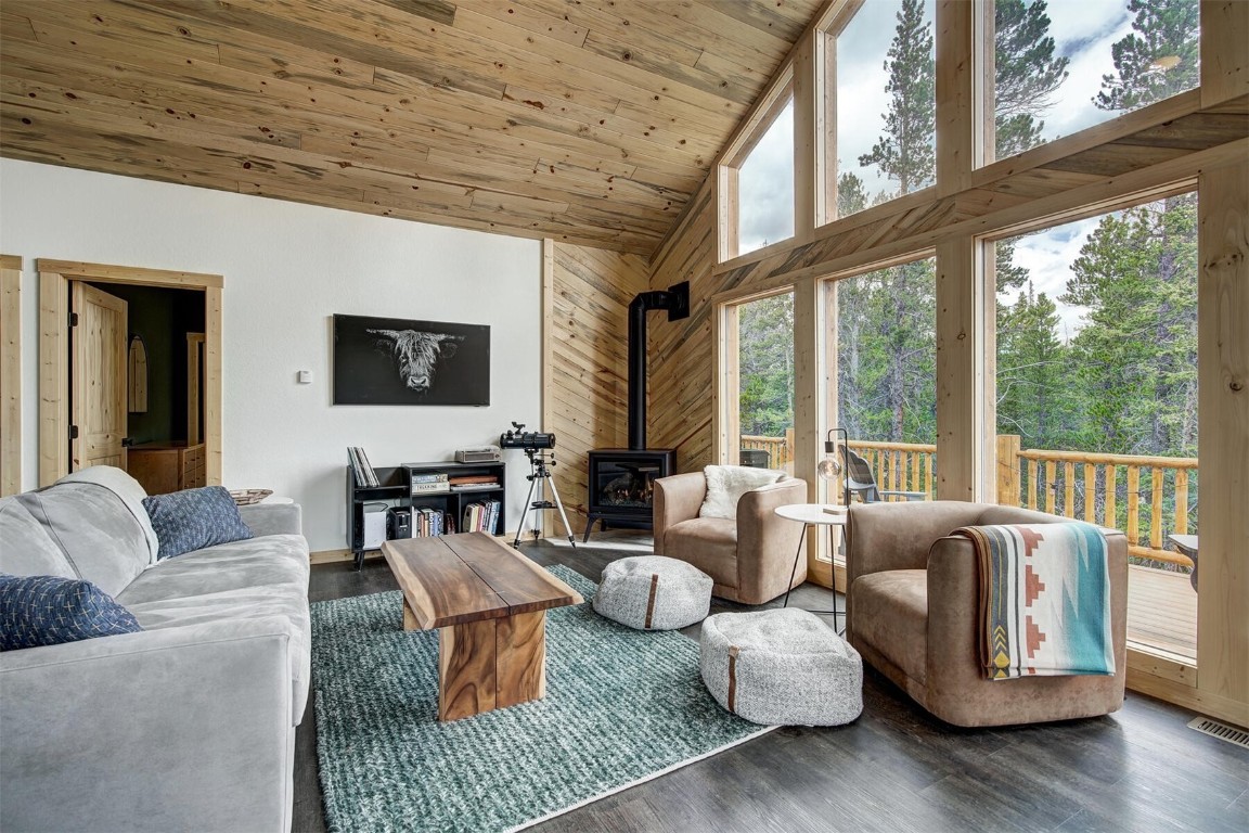 a living room with furniture large windows and wooden floor