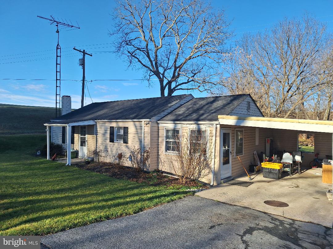 a view of a house with backyard area and a porch