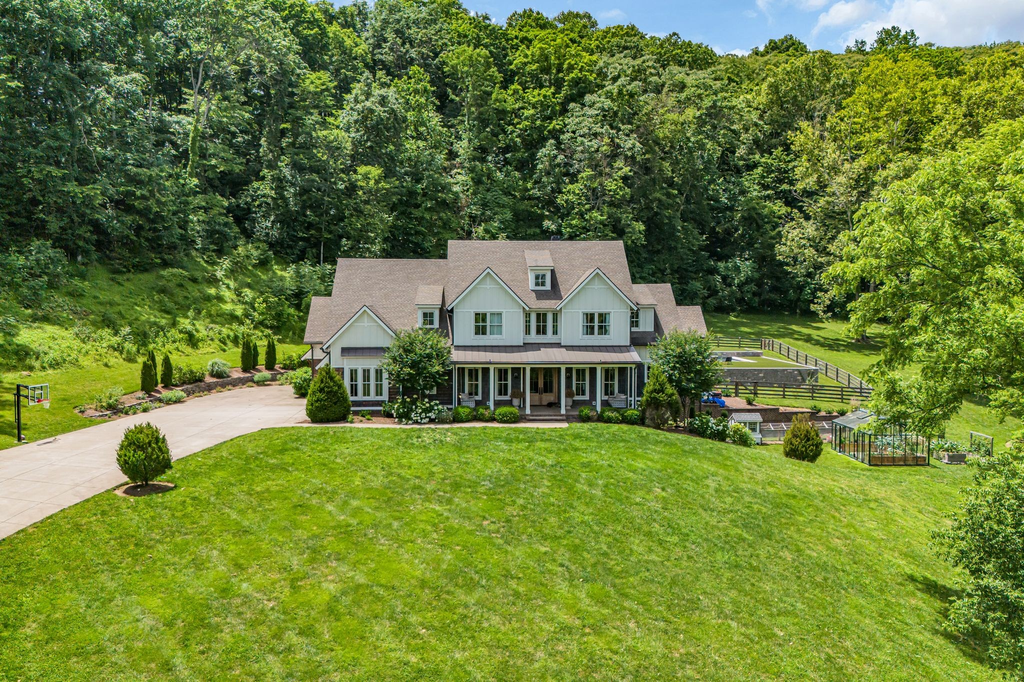 a view of a house with a big yard and large trees