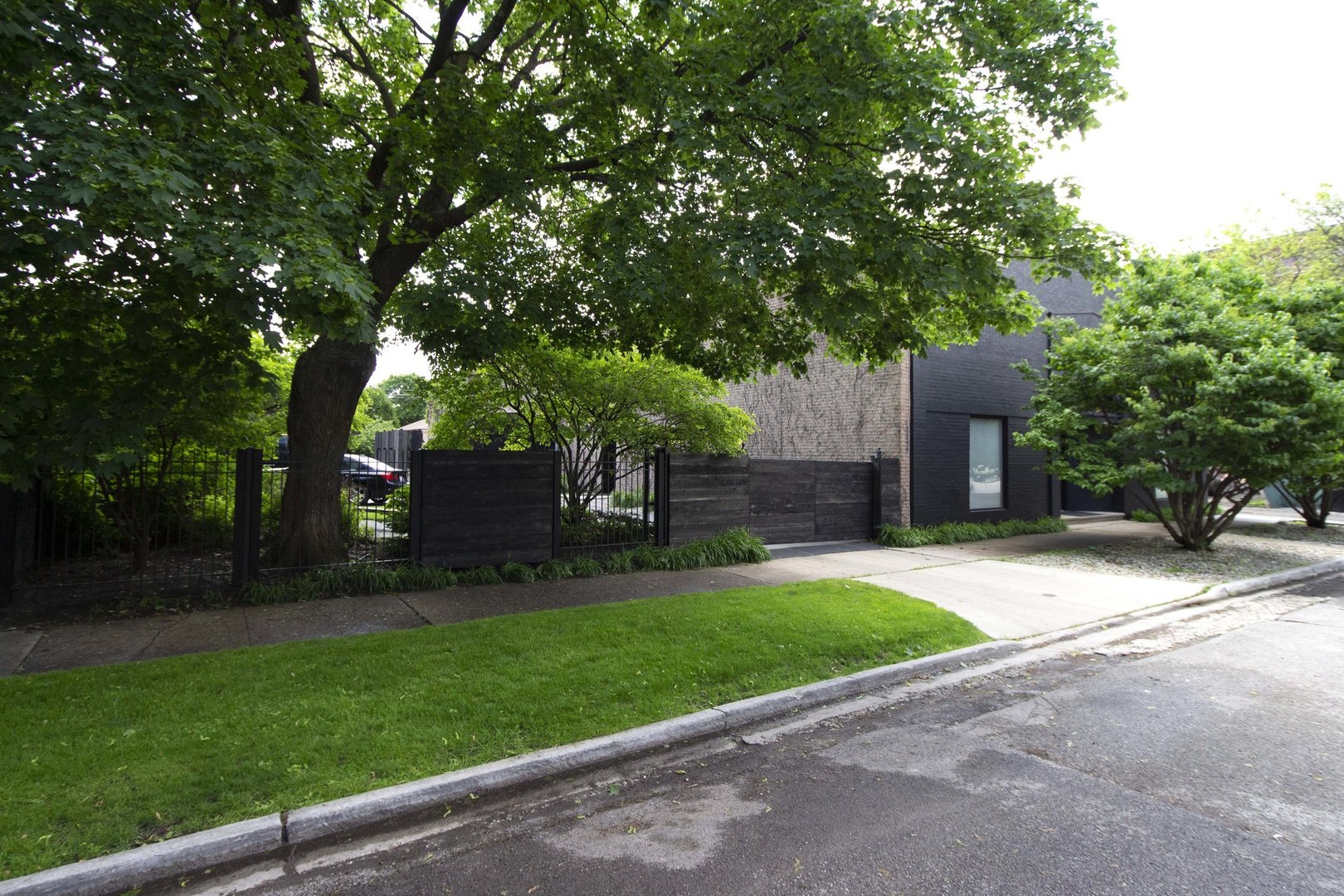 a front view of a house with a garden and trees