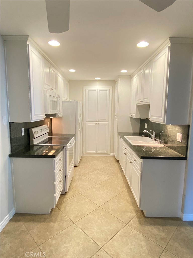 a large kitchen with kitchen island granite countertop a sink and a stove