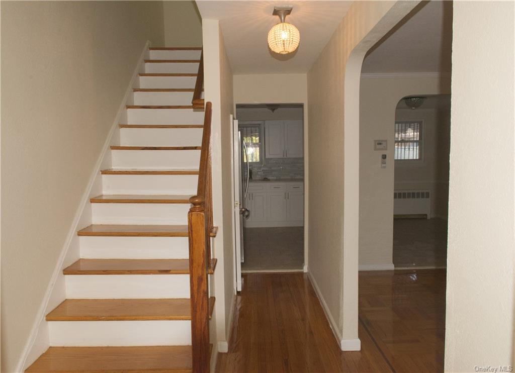 a view of a hallway with wooden floor and entryway