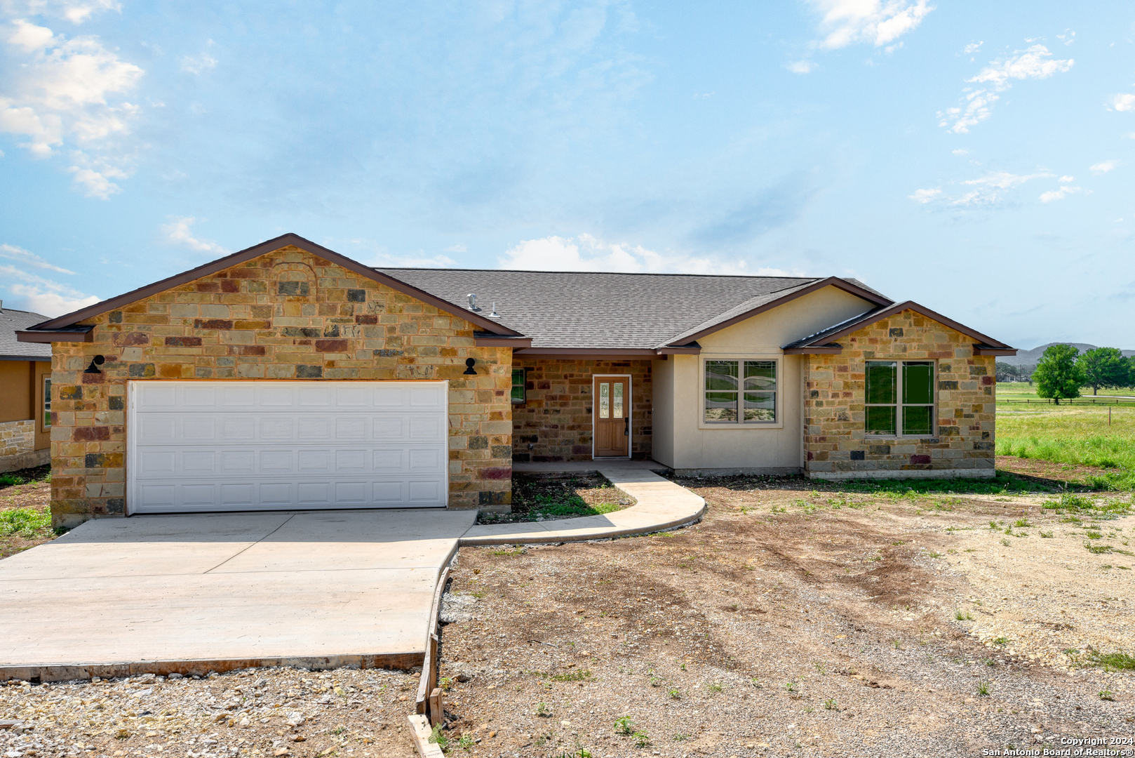 a front view of a house with a yard and garage