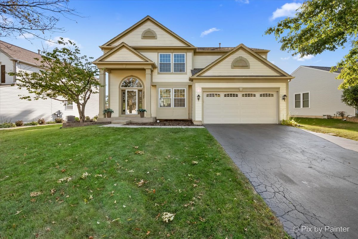 a front view of a house with a yard and garage