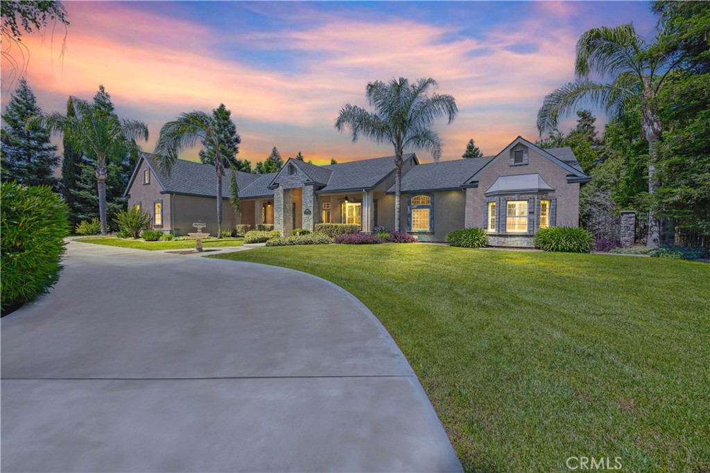 a front view of a house with a garden and trees