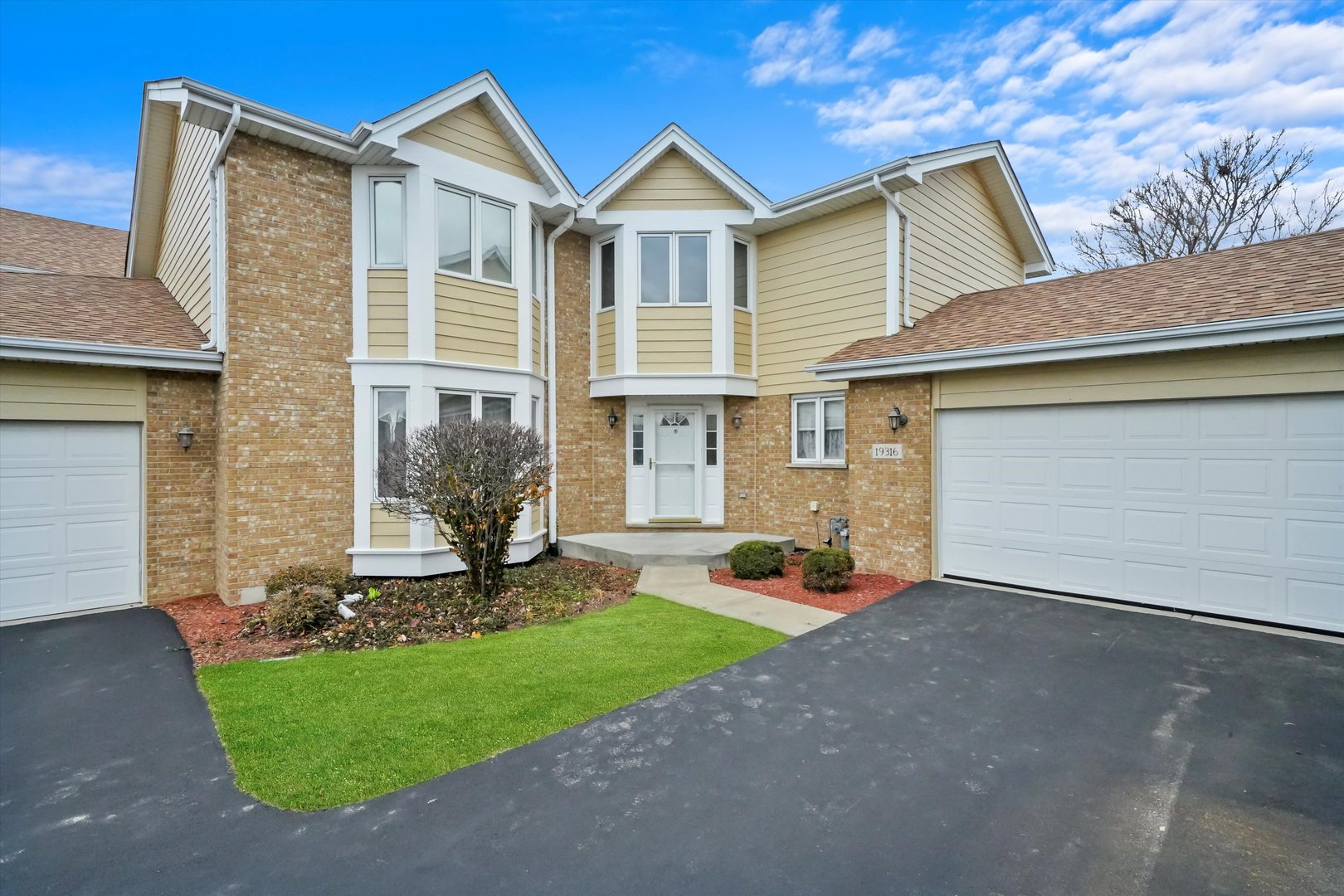 a front view of a house with a yard and garage