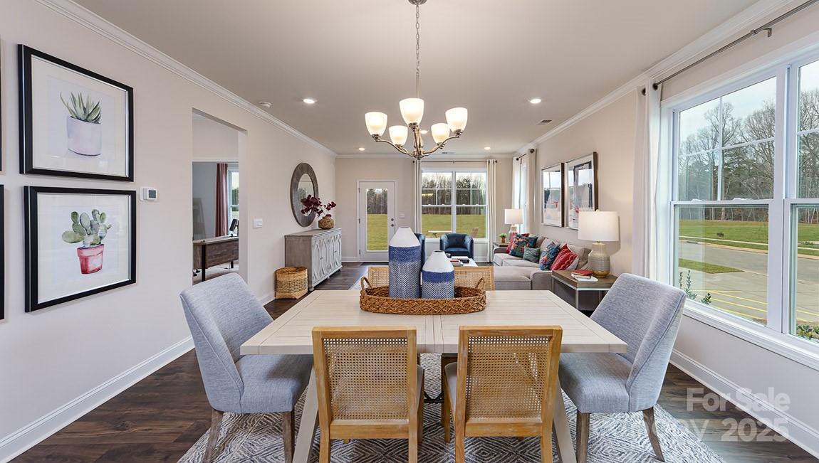 a dining room with wooden floor a chandelier a wooden table and chairs