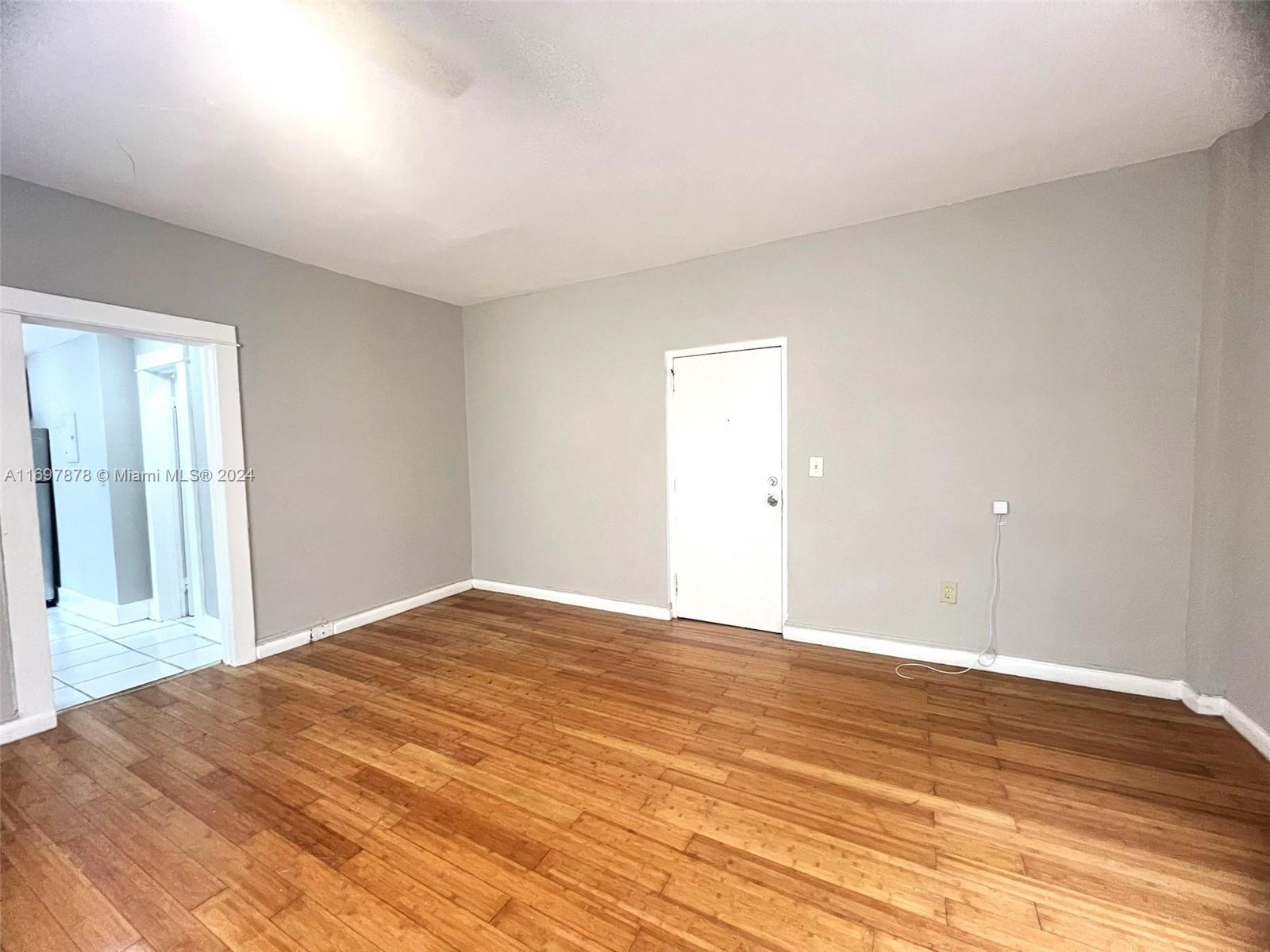 a view of empty room with wooden floor