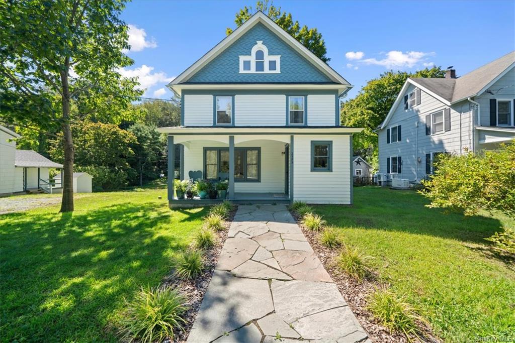 View of front of main home, Gloria, featuring 4BR, 2.5 baths, covered porch, a front lawn with bluestone walkway