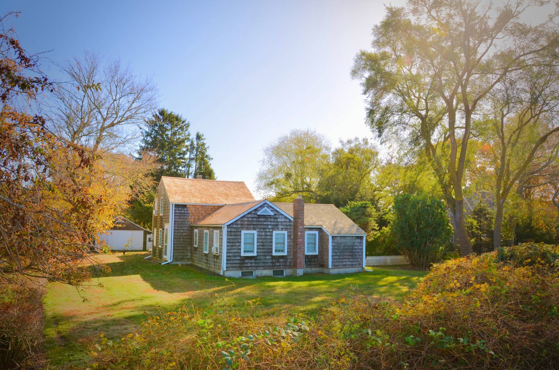 a front view of a house with yard and trees