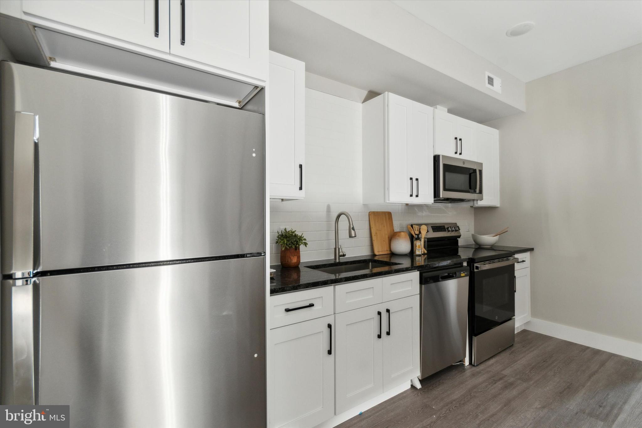 a kitchen with stainless steel appliances a refrigerator sink and cabinets