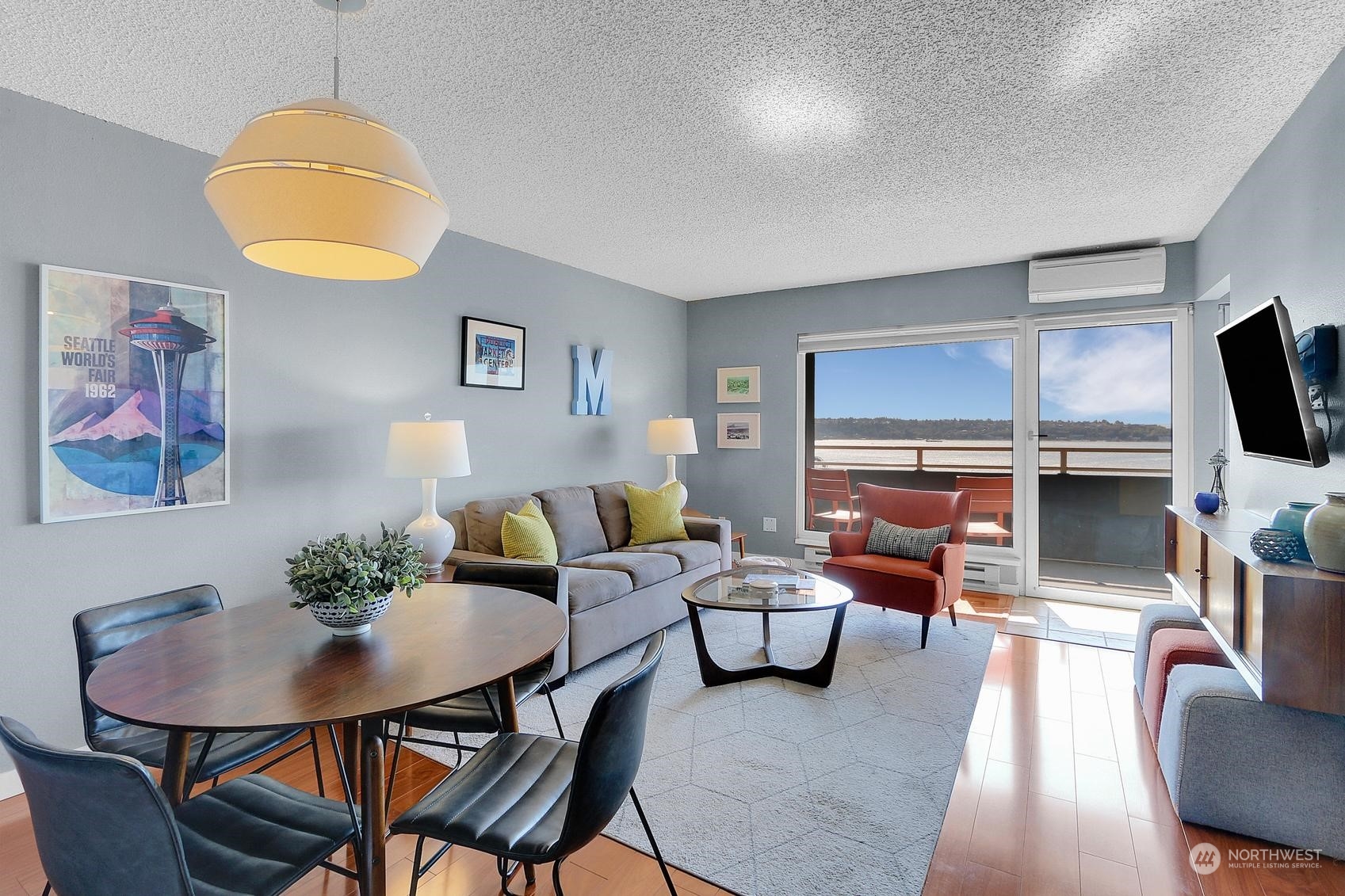 a living room with furniture a flat screen tv and kitchen view