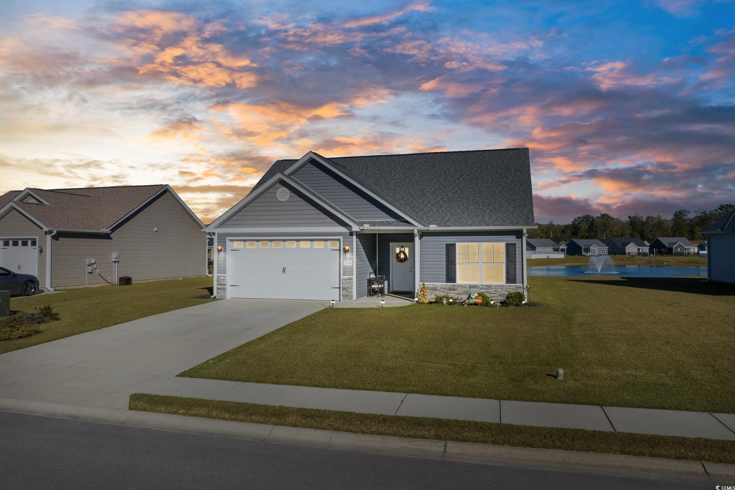 View of front of home with a lawn and a garage