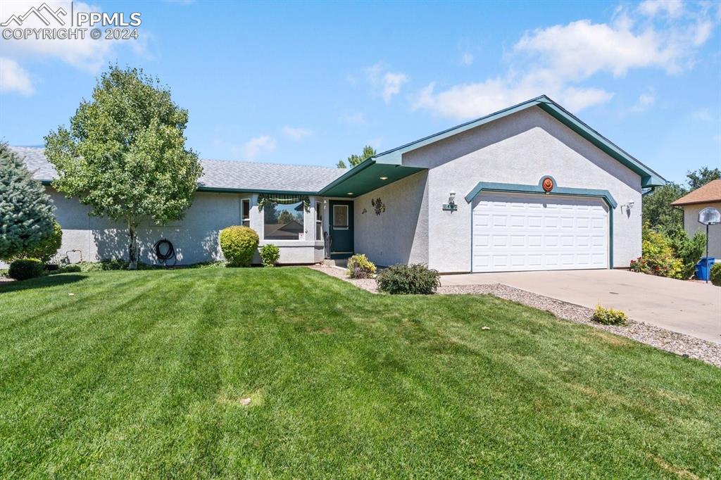 Ranch-style house with a garage and a front yard