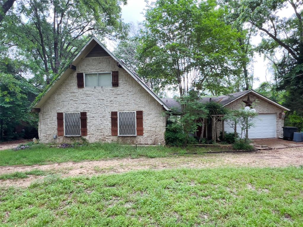 a front view of house with a yard and trees