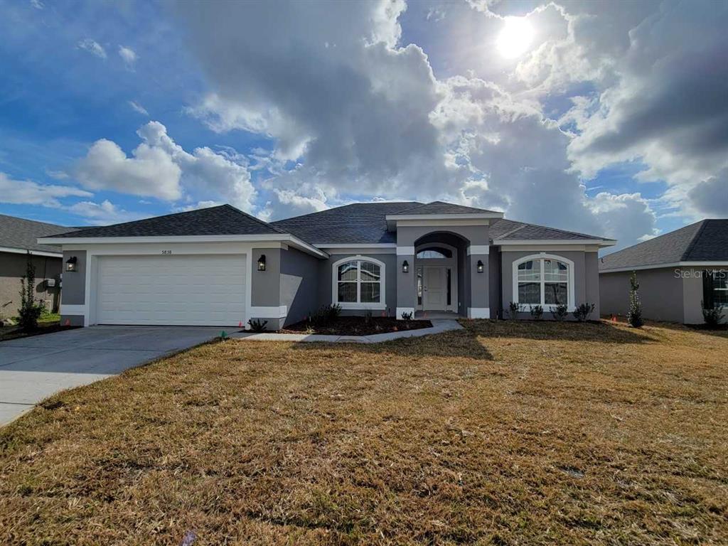 a front view of a house with yard and garage