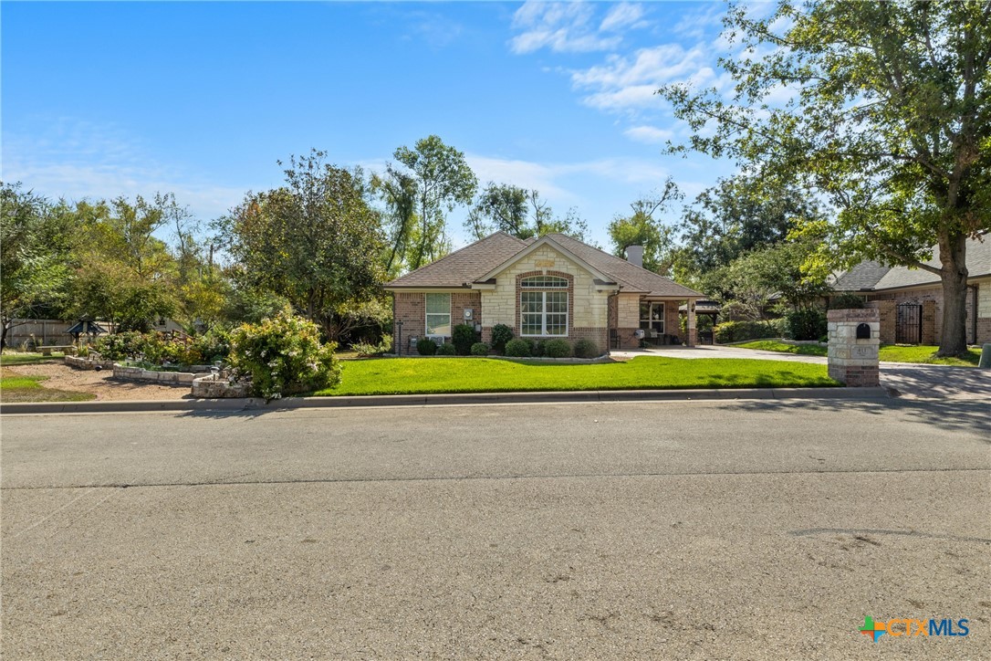 a view of a house with a big yard and large trees